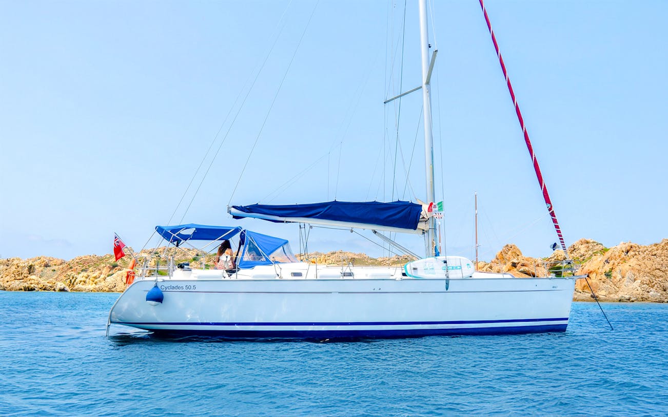 Sailing yacht near rocky islands in La Maddalena Archipelago.