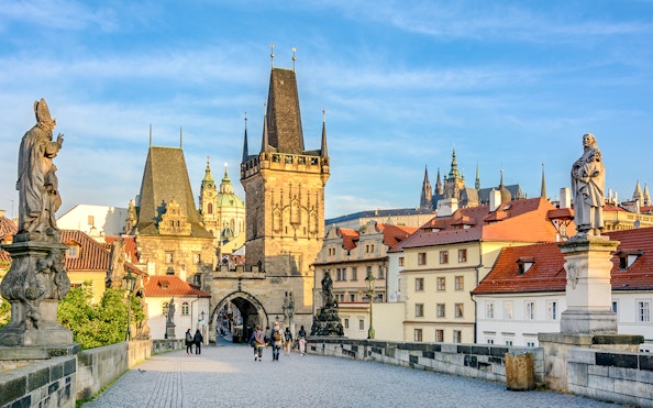 Charles Bridge in Prague with statues and Gothic towers in the background.