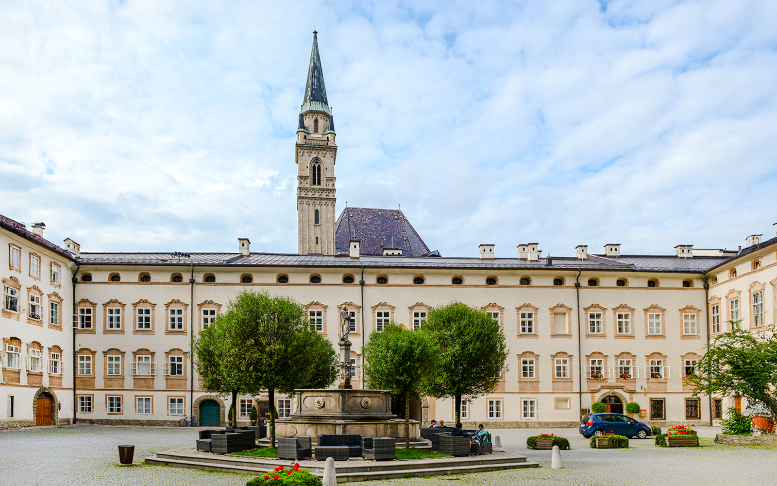 St. Peter monastery courtyard with fountain and tower in Salzburg, Austria.