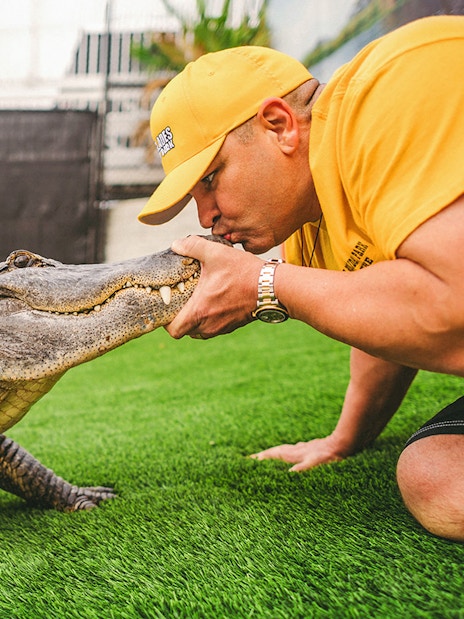 Man interacting with an alligator during Everglades airboat tour.