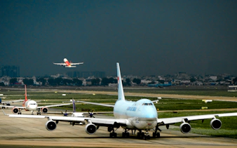 Planes on the runway at Cam Ranh International Airport, Nha Trang, with one taking off.