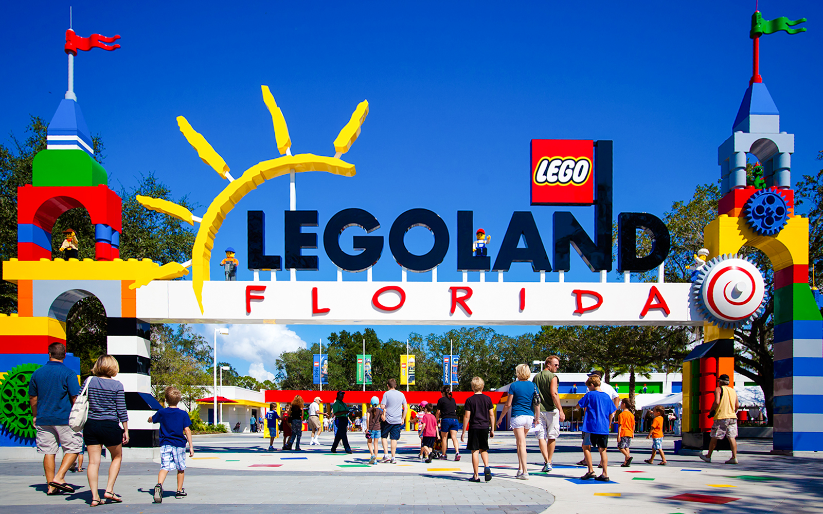 Entrance to Legoland Florida with colorful Lego structures and visitors walking in.