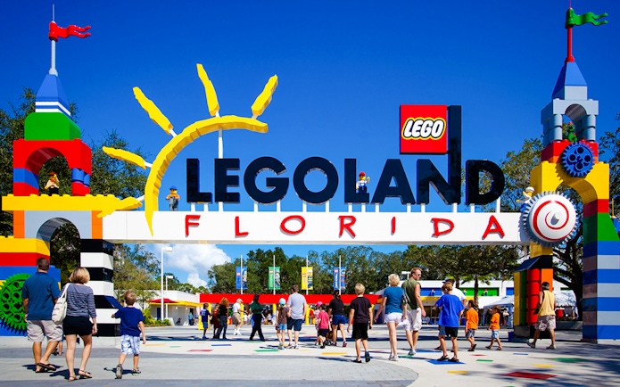 Entrance to Legoland Florida with colorful Lego structures and visitors walking in.