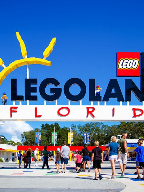 Entrance to Legoland Florida with colorful Lego structures and visitors walking in.