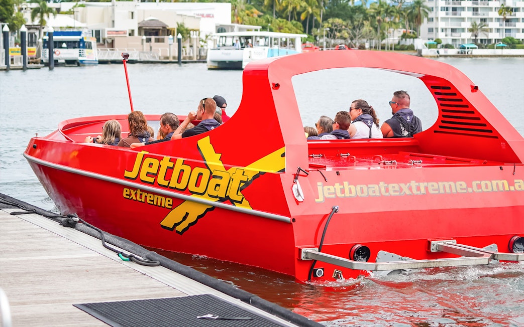 Jet boat with passengers departing dock for Ultimate Jet Boat Ride and Surf Lesson.