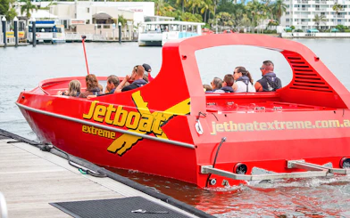 Jet boat with passengers departing dock for Ultimate Jet Boat Ride and Surf Lesson.