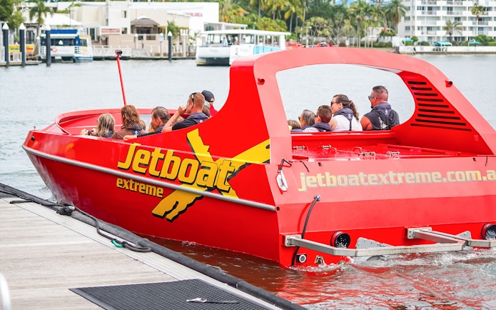 Jet boat with passengers departing dock for Ultimate Jet Boat Ride and Surf Lesson.