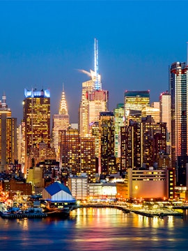 Manhattan midtown skyline with illuminated buildings at dusk, New York City.