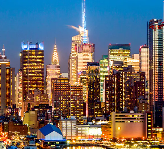 Manhattan midtown skyline with illuminated buildings at dusk, New York City.
