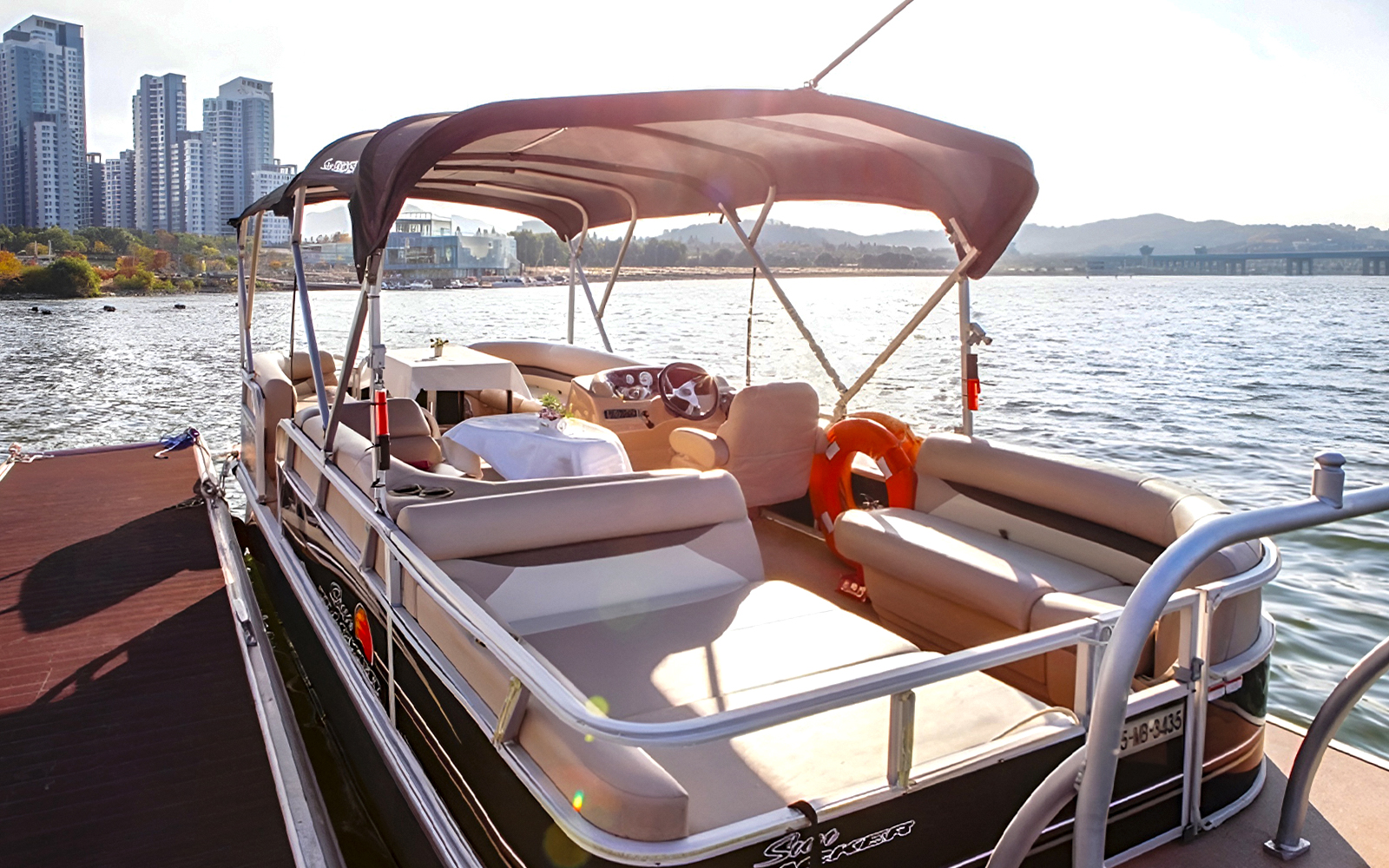 Yacht docked at Han River Marina, Seoul, with city skyline in the background.