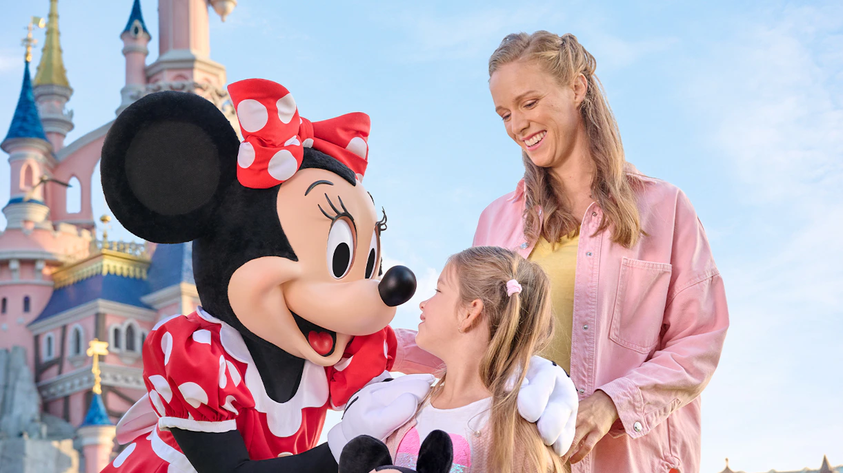 Meeting Minnie Mouse at Disneyland Paris with Sleeping Beauty Castle in the background.