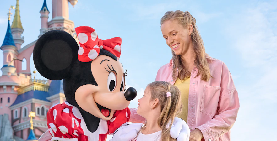 Meeting Minnie Mouse at Disneyland Paris with Sleeping Beauty Castle in the background.