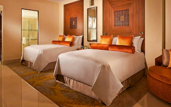 Two double beds in a Fairmont Hotel room with elegant decor and warm lighting.