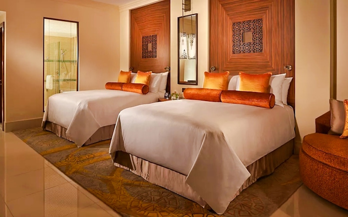 Two double beds in a Fairmont Hotel room with elegant decor and warm lighting.