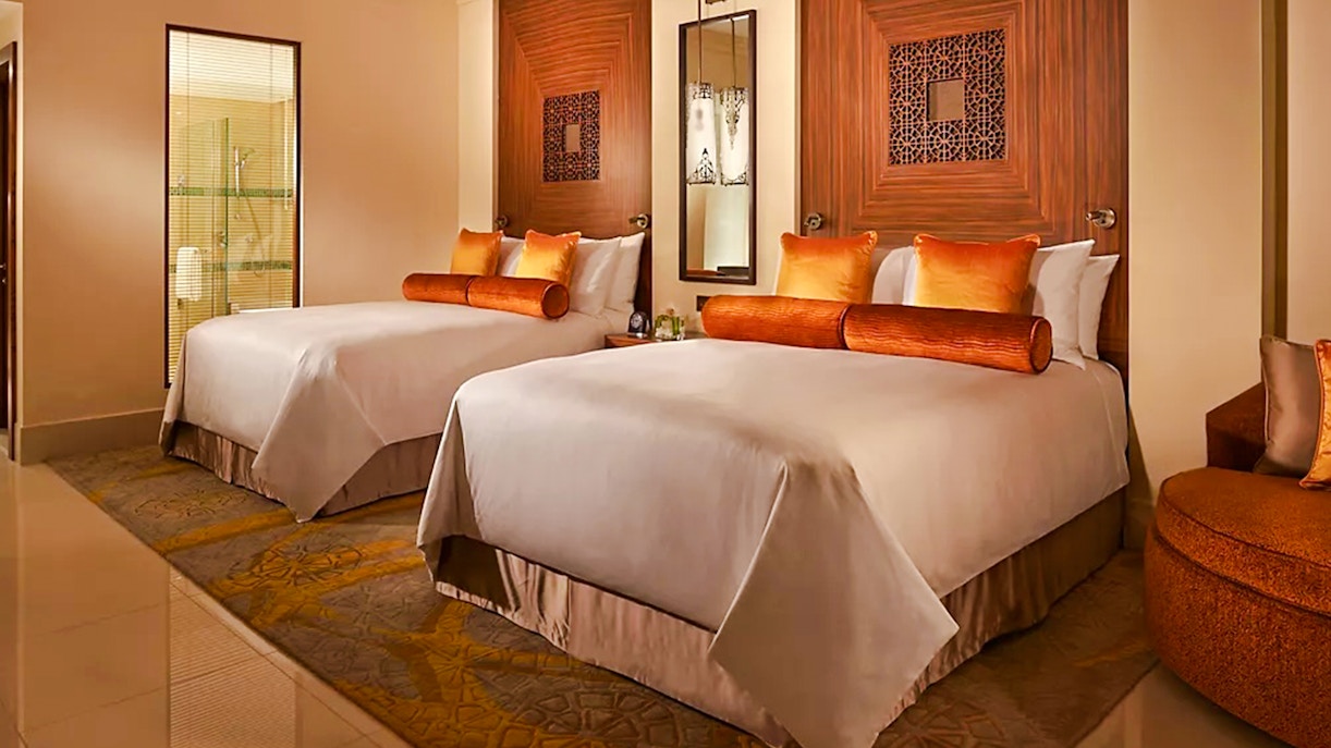 Two double beds in a Fairmont Hotel room with elegant decor and warm lighting.