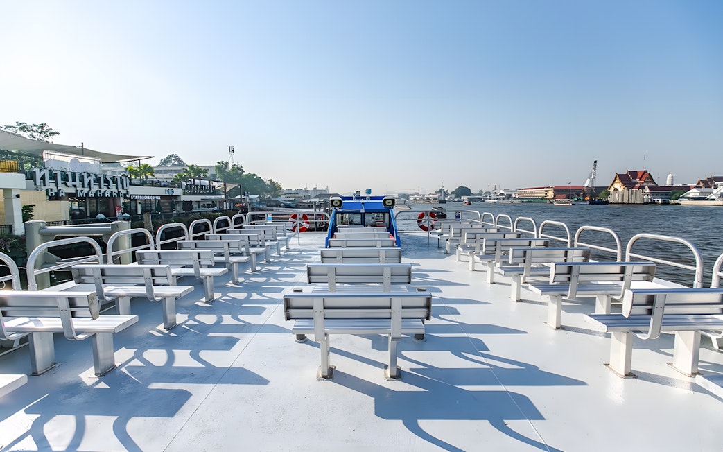 Chao Phraya Tourist Boat with empty seats on a sunny day in Bangkok.