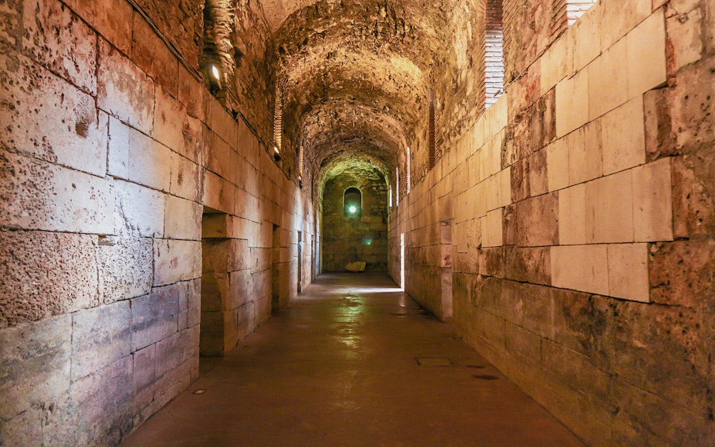 Lower floor corridor of Diocletian's Palace in Split, Croatia, with stone walls and arched ceiling.