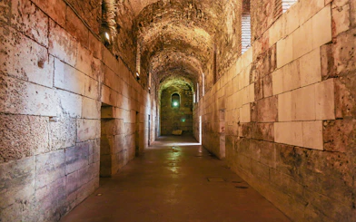 Lower floor corridor of Diocletian's Palace in Split, Croatia, with stone walls and arched ceiling.
