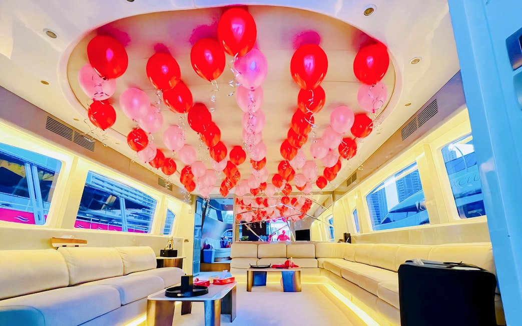 Luxury yacht interior with red and pink balloons for a birthday celebration in Dubai.