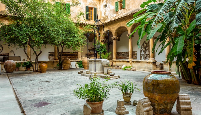 Cloister of Palma Cathedral with arched walkways and stone columns in Palma de Mallorca, Spain.