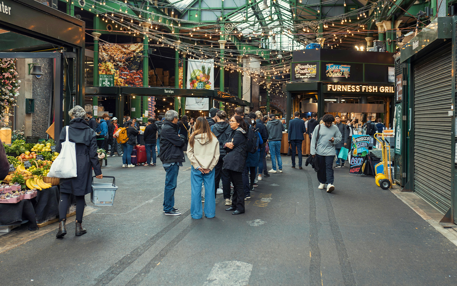 Crowd exploring food stalls at Borough Market, London.