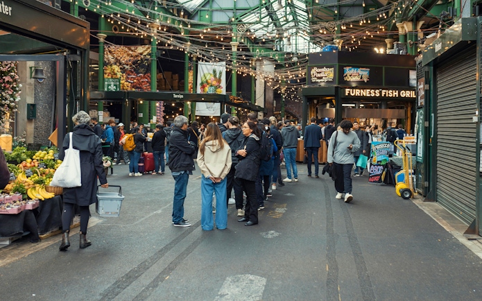 Crowd exploring food stalls at Borough Market, London.