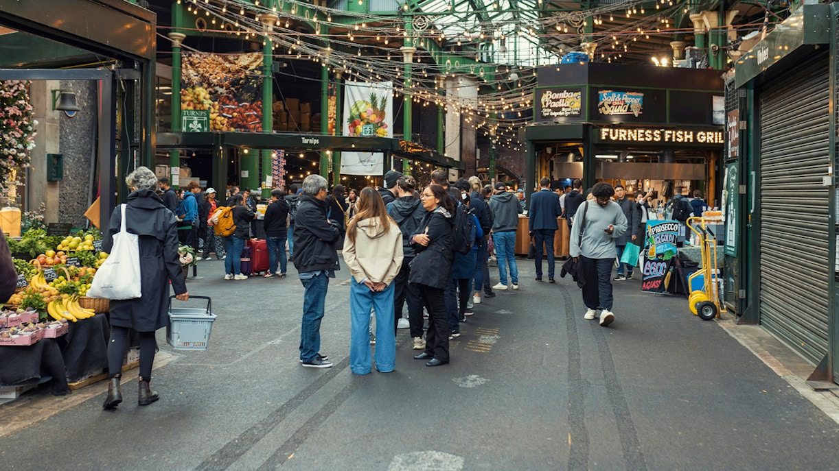Crowd exploring food stalls at Borough Market, London.