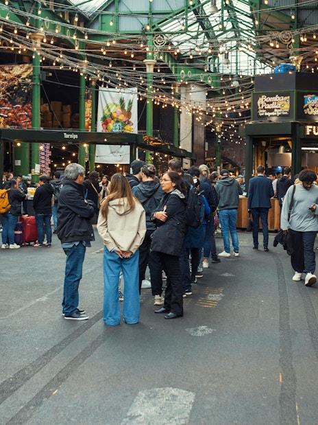 Crowd exploring food stalls at Borough Market, London.