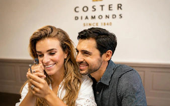 Visitors examining diamonds at Coster Diamonds, Amsterdam's historic factory.