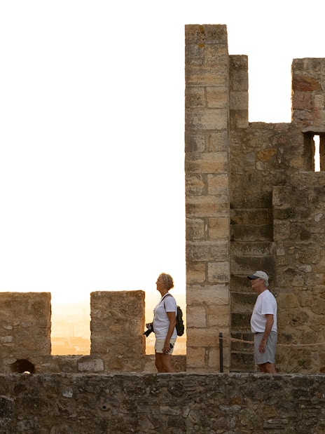 Visitors exploring St George's Castle with a guide at sunset.