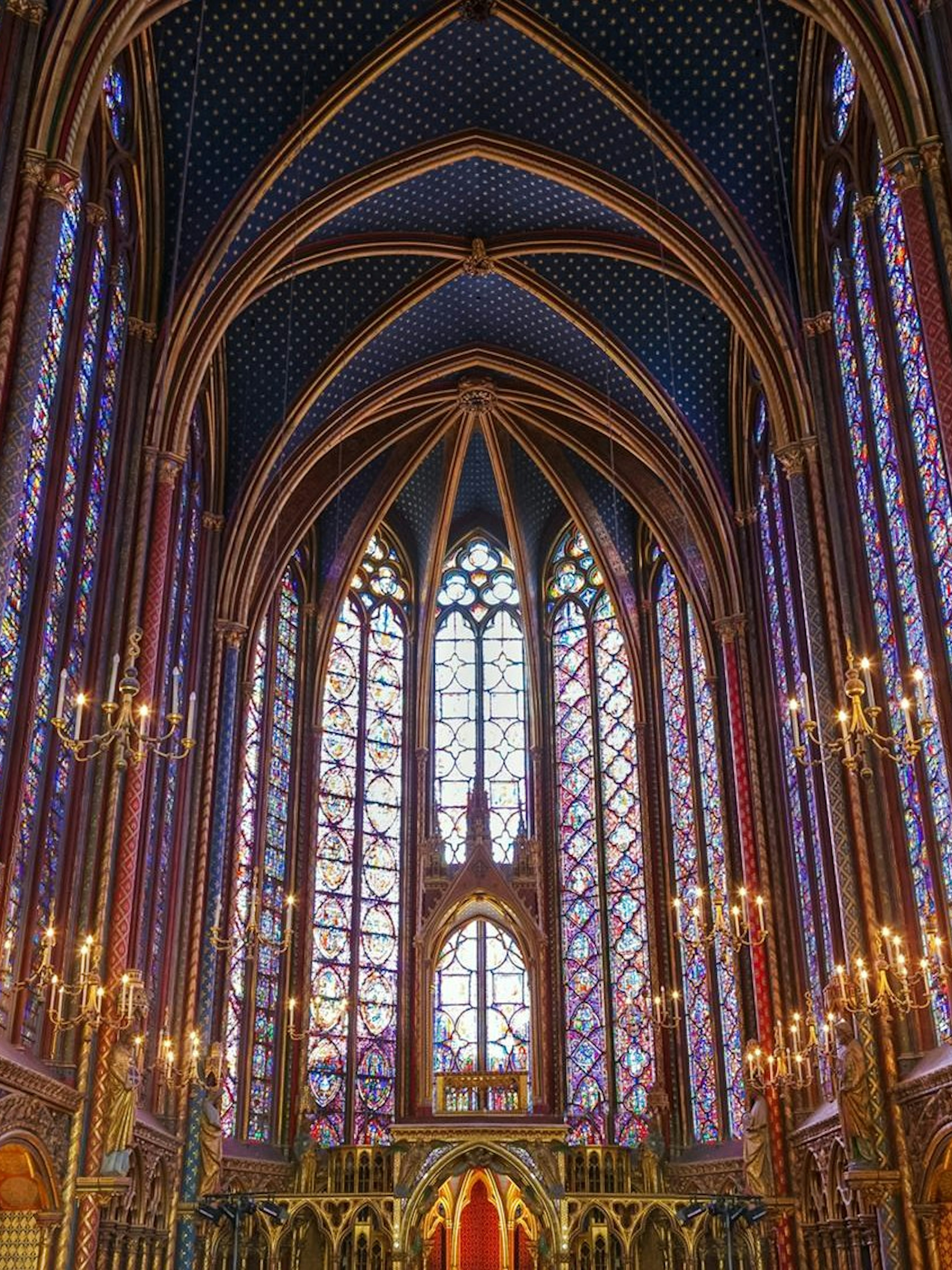 Stained glass windows and vaulted ceiling of Sainte-Chapelle interior in Paris.