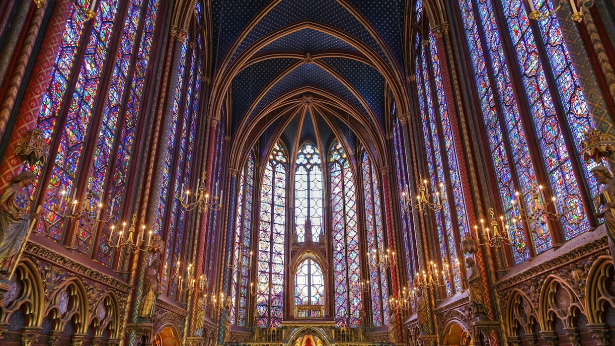 Stained glass windows and vaulted ceiling of Sainte-Chapelle interior in Paris.