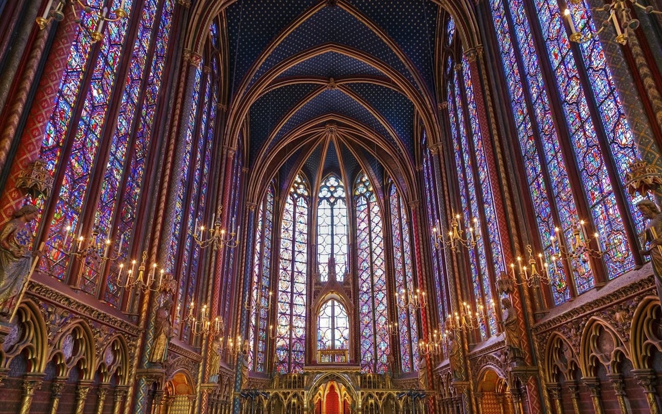 Stained glass windows and vaulted ceiling of Sainte-Chapelle interior in Paris.