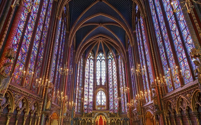 Stained glass windows and vaulted ceiling of Sainte-Chapelle interior in Paris.