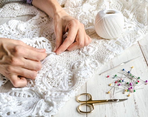 Hands embroidering lace at Bordal Embroidery Factory, Madeira.