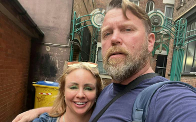 Couple exploring a hidden alley in Manchester during a self-guided city mystery game.
