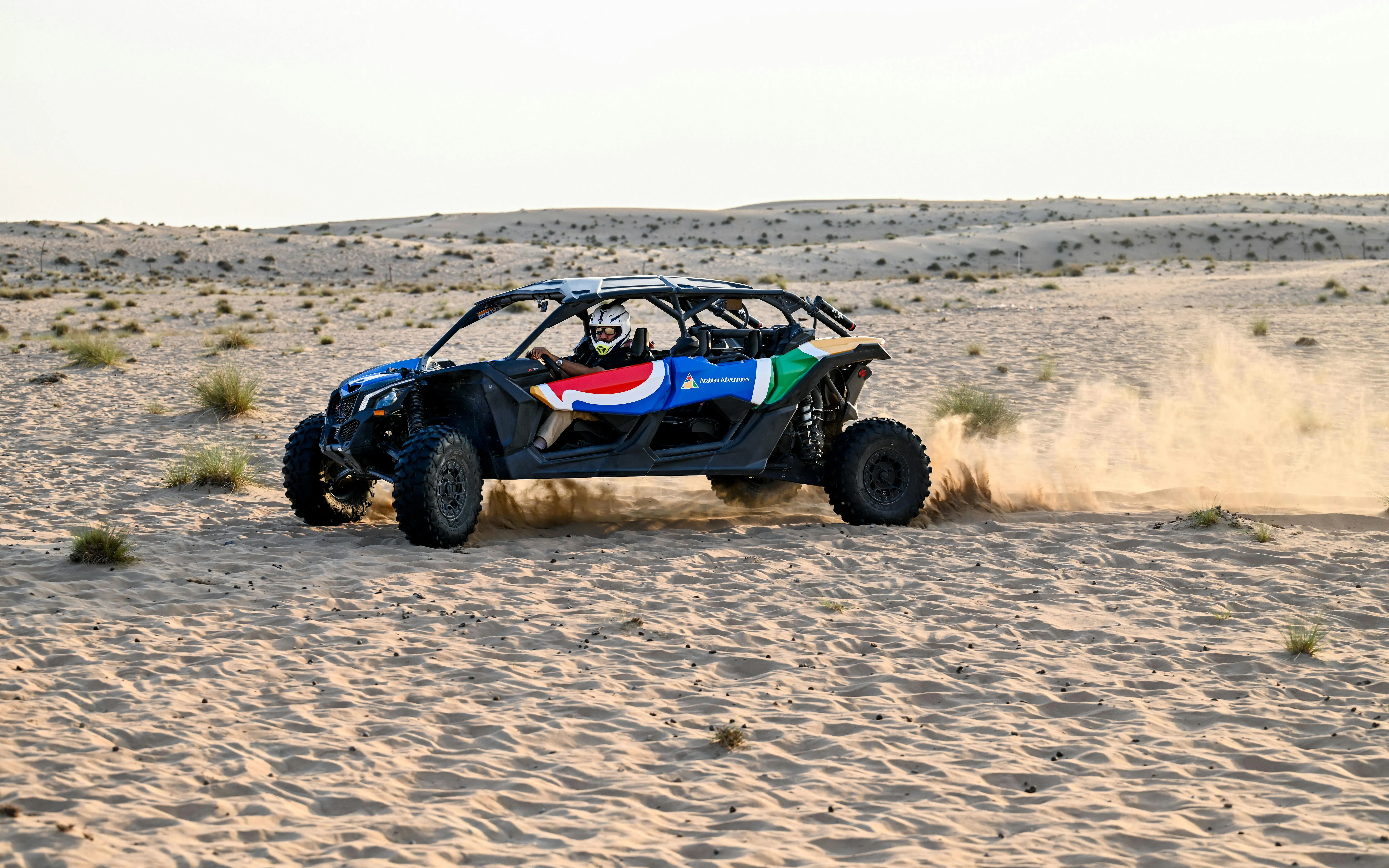 Dune buggy driving through desert landscape during safari adventure.