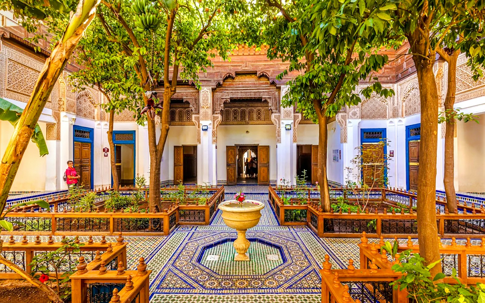 Bahia Palace courtyard with intricate tilework and lush greenery in Marrakech, Morocco.