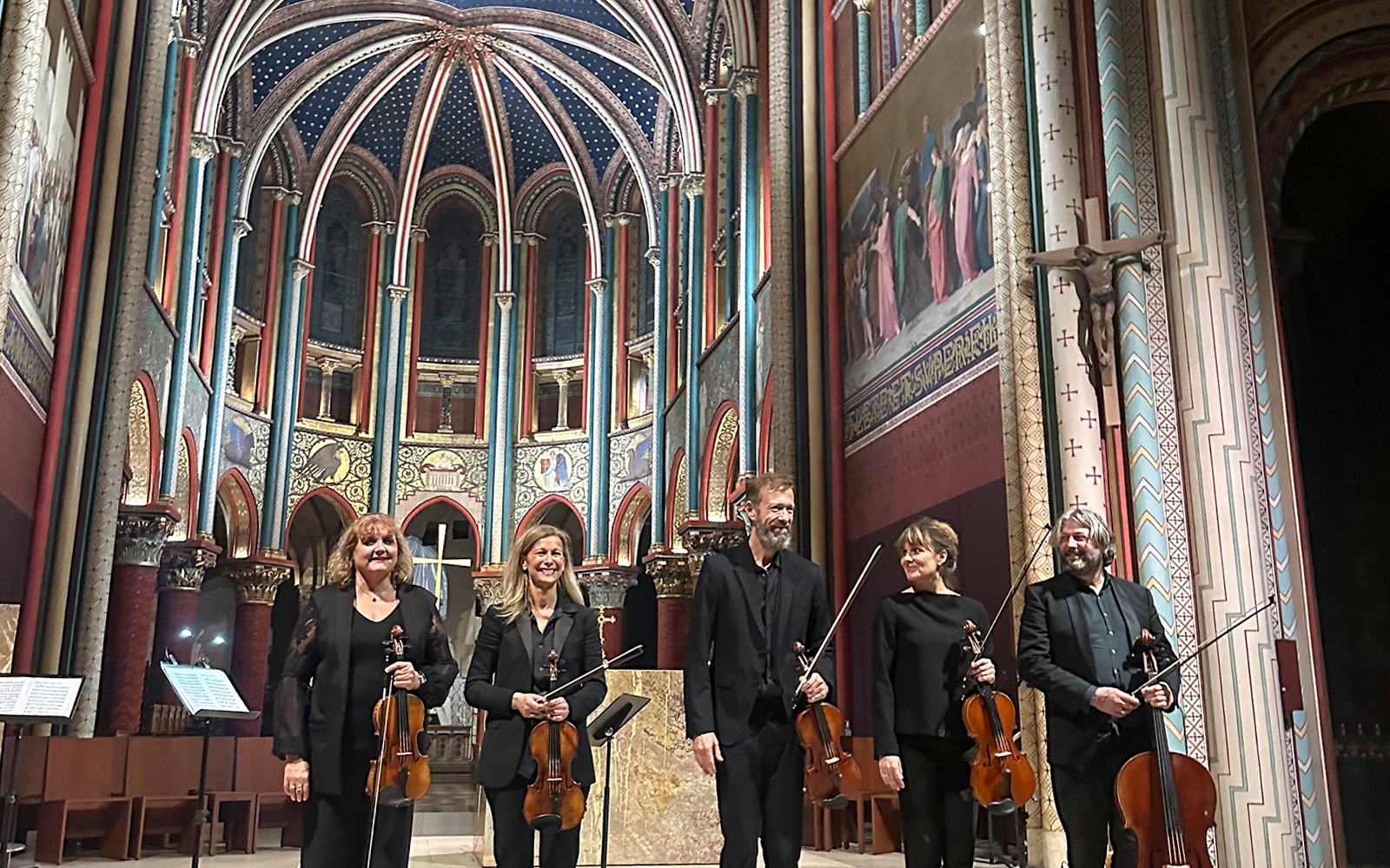Visitors enjoying a mesmerizing concert at Sainte Chapelle, a historic gothic chapel in Paris, France