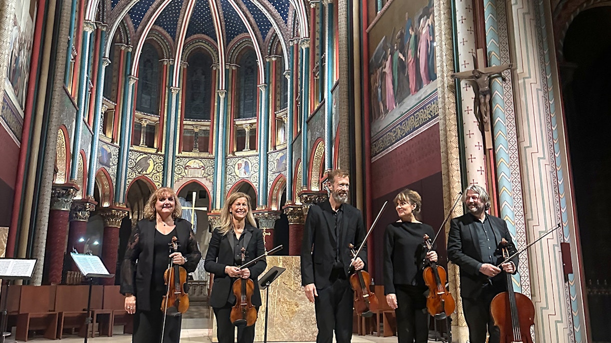 Visitors enjoying a mesmerizing concert at Sainte Chapelle, a historic gothic chapel in Paris, France