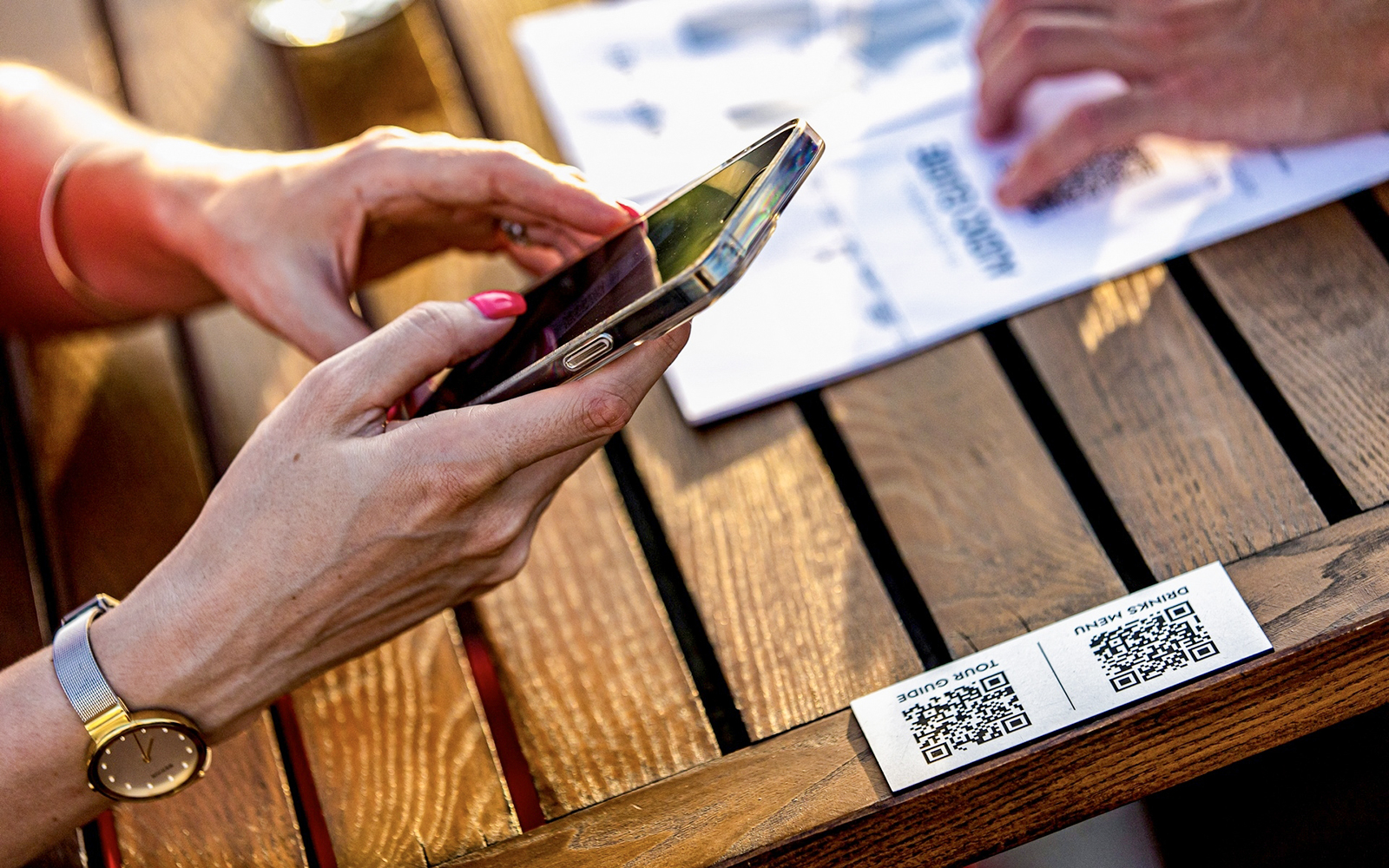 Guests using audio guide on Budapest Danube River nighttime sightseeing cruise with city lights in background