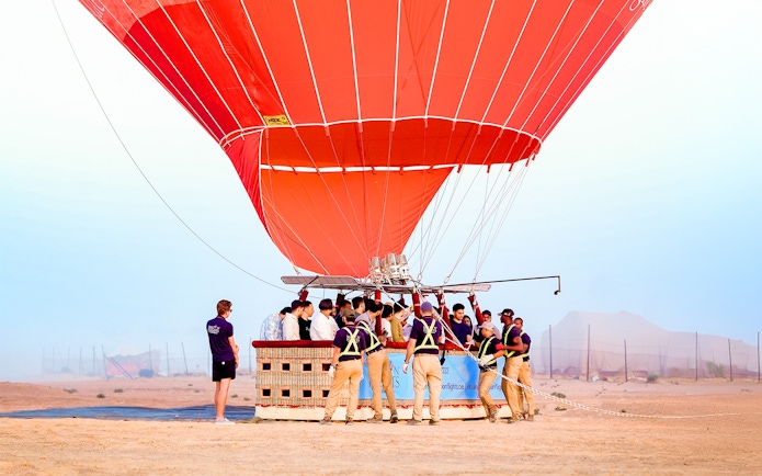 Hot air balloon preparing for launch in Dubai desert.