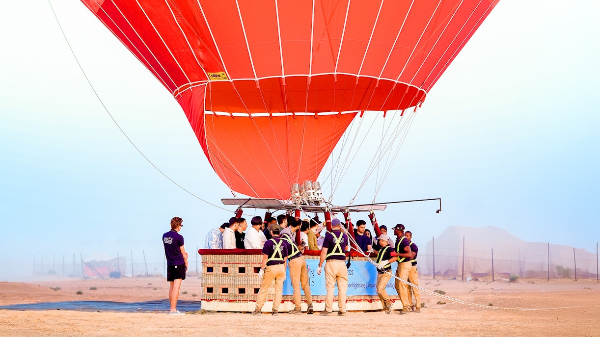 Hot air balloon over Dubai desert with camel ride and quad biking experience.
