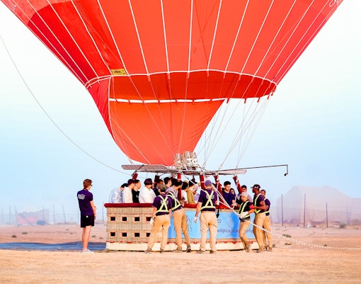 Hot air balloon preparing for launch in Dubai desert.
