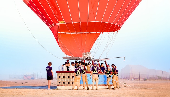 Hot air balloon preparing for launch in Dubai desert.