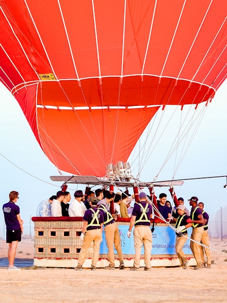 Hot air balloon preparing for launch in Dubai desert.