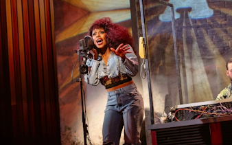 Singer performing "I'm Every Woman" on West End stage.