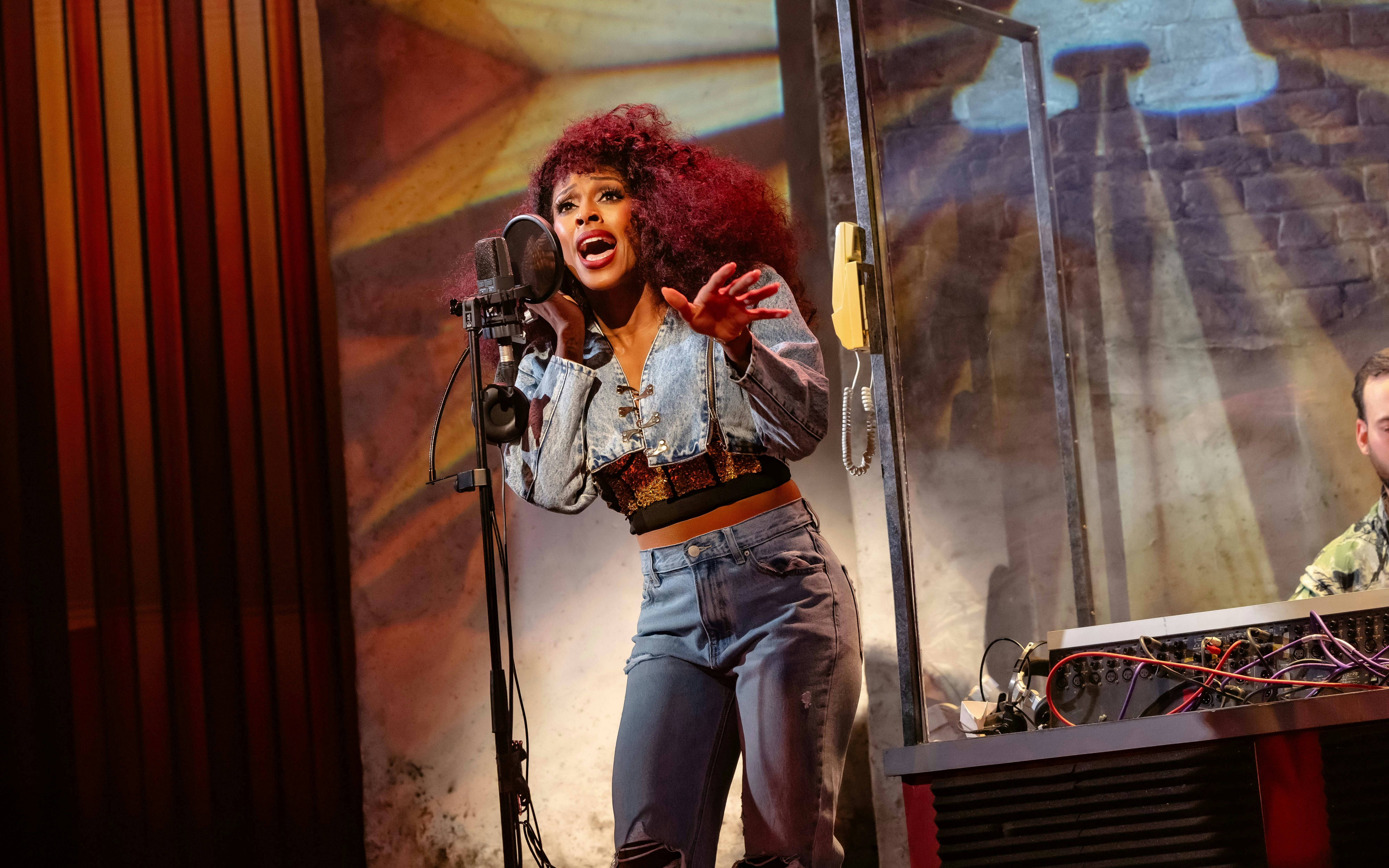 Singer performing "I'm Every Woman" on West End stage.