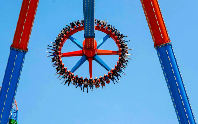 Guests on Crazanity ride at Six Flags Mexico against blue sky.