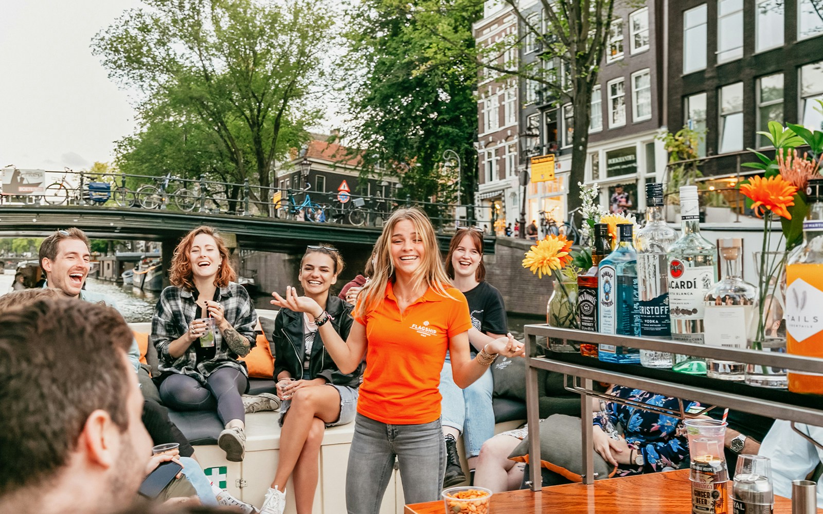 Guide on board Classic Boat Cruise in Amsterdam serving cheese and wine.